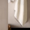 Bath towel with contrasting pom-poms