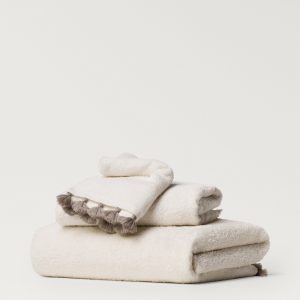 Towel with contrasting pom-poms