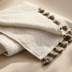 Washbasin towel with contrasting pom-poms